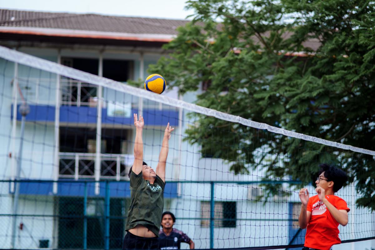 Pickup volleyball players gathering around an outdoor court